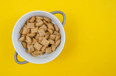 Sarı zemin üzerinde çikolata olan mısır gevreği kasesi, kopyalama alanı, üst görünüm