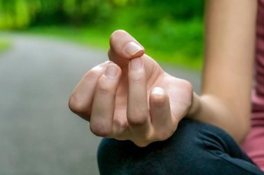 Lotus pozisyonunda bir kadının elinin yakın çekimi.