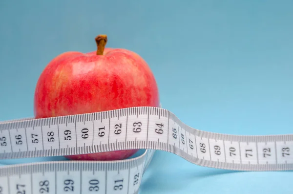 红色苹果 白色厘米特写 蓝色背景 健康饮食概念 卡路里计数和体重减轻 — 图库照片