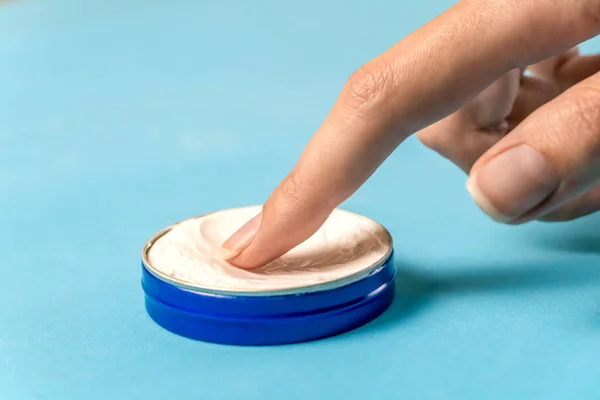 Dedo Mujer Toca Una Crema Blanca Frasco Metal Azul Sobre — Foto de Stock