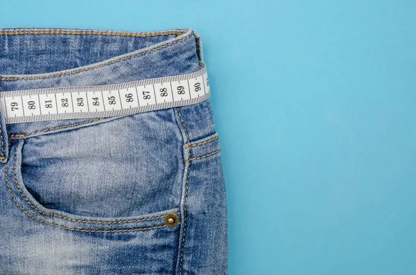 蓝色牛仔裤 带有白色的测量带 而不是蓝色背景的腰带 复制空间 顶部视图 健康生活方式和饮食的概念 — 图库照片