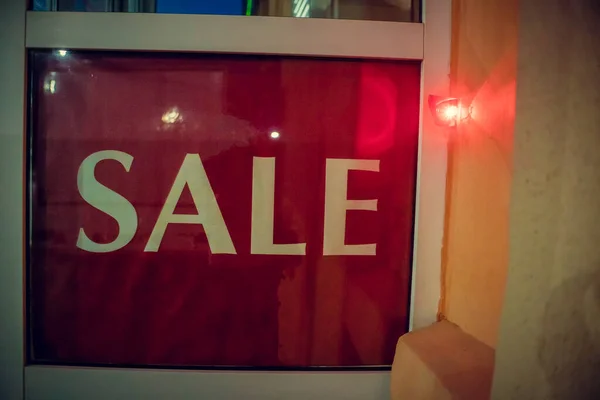 Sign Sale in a shop window at night on the street with an alarm close-up. Cyber Monday and black Friday sales concept