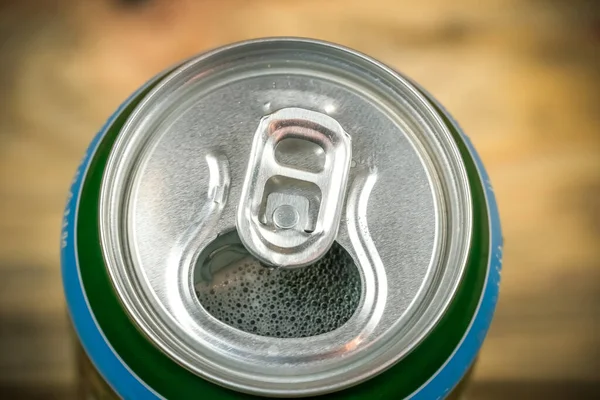 Open beer can with foam, macro photography, top view