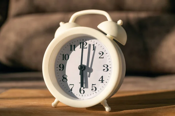 Reloj Despertador Blanco Sobre Una Mesa Madera Sobre Fondo Sofá —  Fotos de Stock