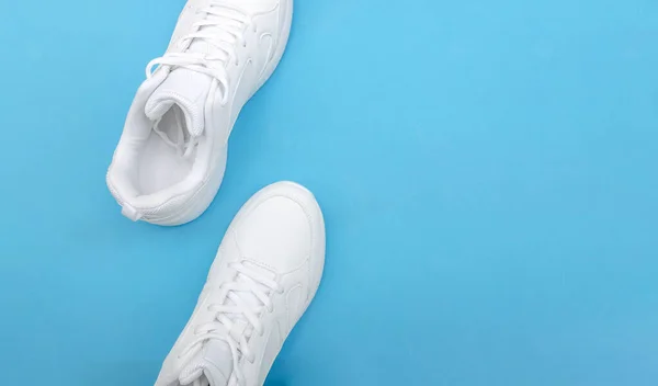 Witte Sneakers Een Blauwe Achtergrond Kopieerruimte Bovenaanzicht — Stockfoto