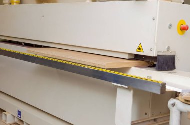 Kenar bantlı bir makinenin tahta parçasının yakın çekimi. Marangoz atölyesinde ahşap işçiliği.