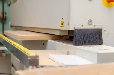 Kenar bantlı bir makinenin tahta parçasının yakın çekimi. Marangoz atölyesinde ahşap işçiliği.