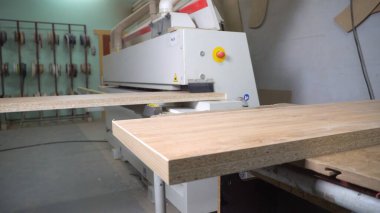 Kenar bantlı bir makinenin tahta parçasının yakın çekimi. Marangoz atölyesinde ahşap çalışma makinesi. Mobilya üretimi için dükkan.