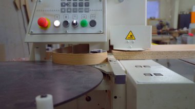 Kenar bantlı bir makinenin tahta parçasının yakın çekimi. Marangoz atölyesinde ahşap çalışma makinesi. Mobilya üretimi için dükkan.