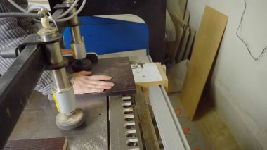 Odun kesmek için otomatik sondaj makinesi. Tahta parçaları için delik açmak. Kapatın. Süreci bir kişi yönetir. Mobilya üretimi.