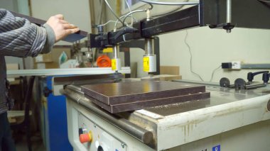 Odun kesmek için otomatik sondaj makinesi. Tahta parçaları için delik açmak. Kapatın. Süreci bir kişi yönetir. Mobilya üretimi.