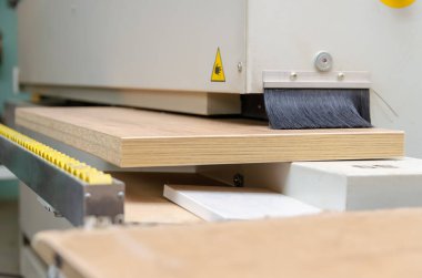 Kenar bantlı bir makinenin tahta parçasının yakın çekimi. Marangoz atölyesinde ahşap işçiliği.