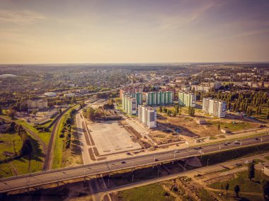 Şehrin yeni binaları, köprüsü, inşaatı olan bir bölümü. Yaz günü gün batımında, insansız hava aracının manzarası..
