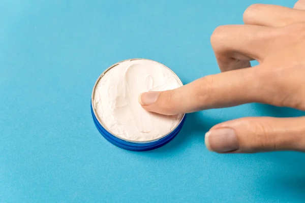 Dedo Mujer Toca Una Crema Blanca Frasco Metal Azul Sobre — Foto de Stock