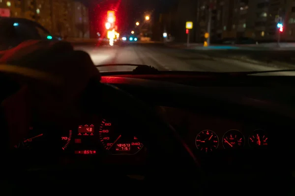 司机的手放在方向盘上 方向盘上有红色灯火通明的仪表盘 照片来自车体内部 — 图库照片