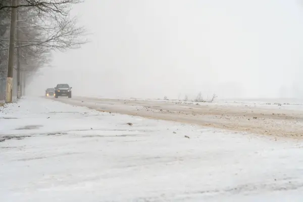 下着雪 两辆车在白雪覆盖的路上行驶 — 图库照片