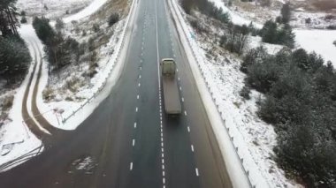 Kış yolu, araba ve kamyon trafiği. Ormanın kenarlarında..