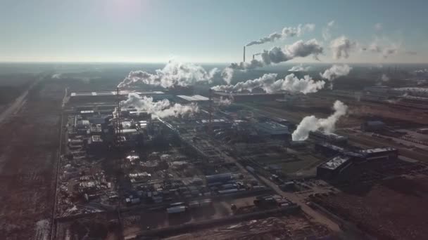 一架无人驾驶飞机发射了一个工业区 浓雾笼罩在阳光的轮廓中 从上方俯瞰工厂区 城市地区许多工厂管道中的空气污染和烟尘 — 图库视频影像