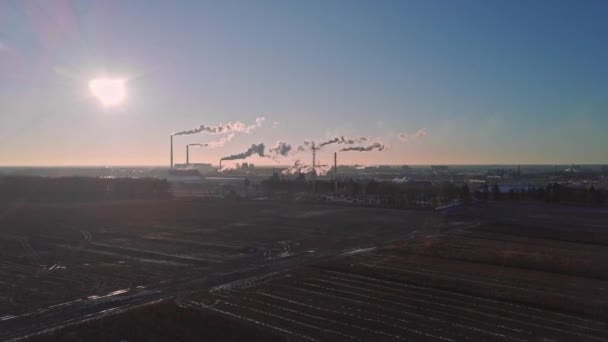 Vista aérea de fábricas com névoa grossa de tubos na luz contornada do sol. — Vídeo de Stock