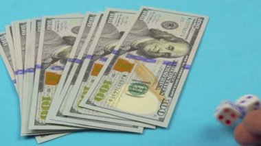 Masada 100 dolarlık banknotlar var, el onlara zar atıyor..