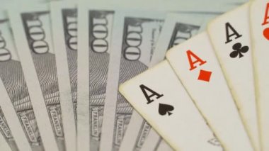 Oyun masasında dört as ve yüz dolarlık banknotlar var..