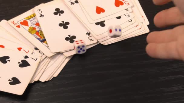 Λευκά ζάρια, σε ένα μαύρο τραπέζι παιχνιδιού με χαρτιά για να παίξετε — Αρχείο Βίντεο
