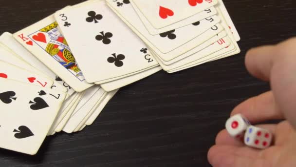 Dados blancos, en una mesa de juego negro con cartas para jugar — Vídeo de stock