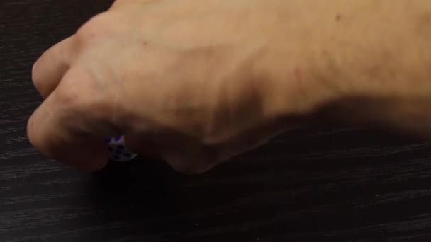 Ręka rzuca kostką na drewniany stół. Zbliżenie — Wideo stockowe