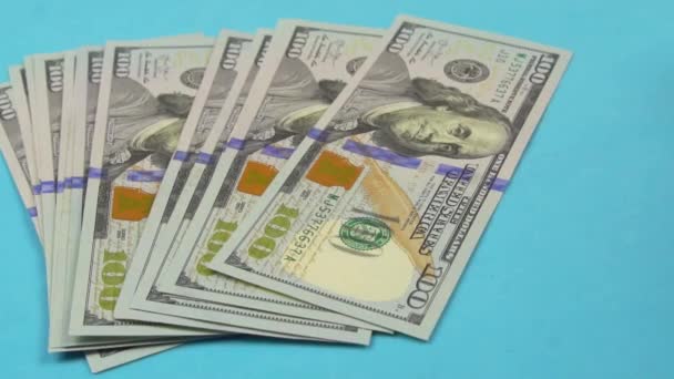 Az asztalon 100 dolláros bankjegyek vannak, a kéz kockát dob rájuk.. — Stock videók