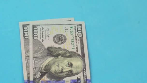 A mão de um homem coloca uma nota de cem dólares na mesa e conta rapidamente — Vídeo de Stock