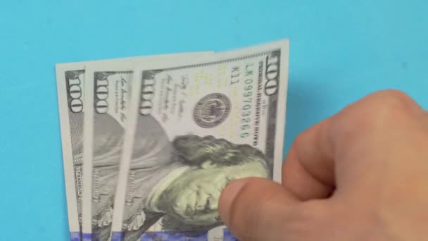 Une main d'homme met des billets de 100 dollars sur la table. — Video