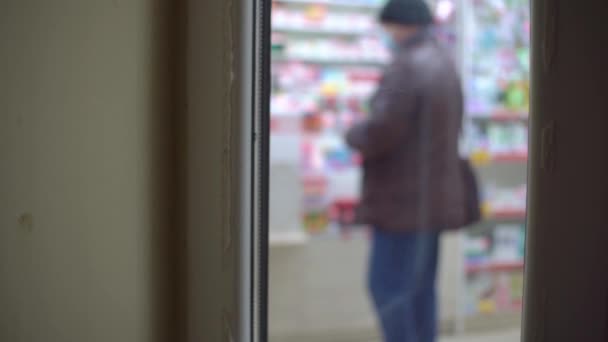 ガラスのドアから撃つと薬局で行列ができる. — ストック動画