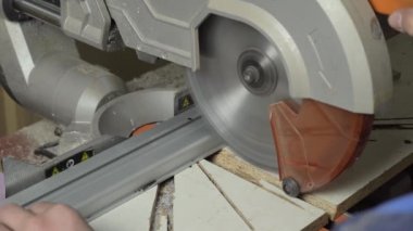 Adamın biri kesme makinesinde metal bir profil kesiyor..