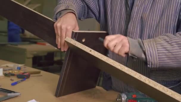 Primo piano di un maestro in un laboratorio di mobili, assemblaggio di piastrelle di legno. — Video Stock