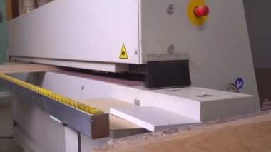 Kenar bantlı bir makinede tahta bir parçanın yakın plan görüntüsü.