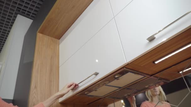 Une femme ouvre la cuisine Cabinet pour sécher la vaisselle. — Video