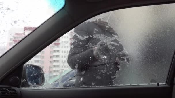 Γυναίκα ξύνει πάγο από το παρμπρίζ του αυτοκινήτου της μετά από ένα μεγάλο πάρκινγκ. — Αρχείο Βίντεο
