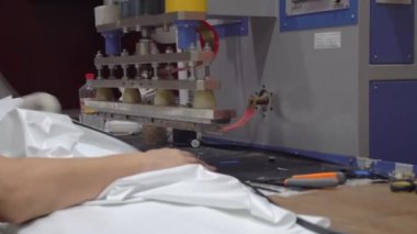 Bir adam PVC filmli bir HDTV kaynak makinesinde çalışıyor..