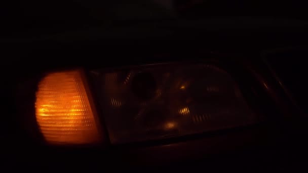 Närbild av den gula främre högra ljuset blinkar på bilen. — Stockvideo