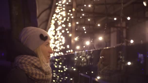 Una donna guarda la ghirlanda della città in previsione della vacanza. — Video Stock