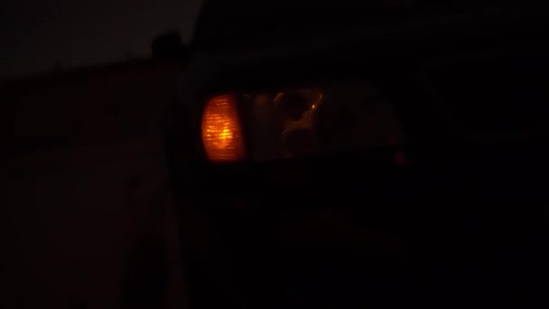 Close-up van het gele voorlicht rechts knipperend op de auto. — Stockvideo