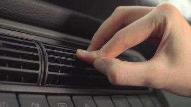 Araba sürücüsünün sıcak hava kullanarak ellerini ısıttığı yakın plan.,