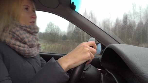 Flicka är ledsen vid ratten i bilen, hon ser tankfullt ut fönstret — Stockvideo