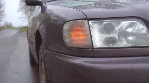Close-up van het gele voorlicht rechts knipperend op de auto. — Stockvideo