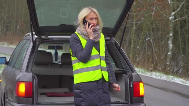 一个女人站在破车旁，一边用智能手机打电话. — 图库视频影像