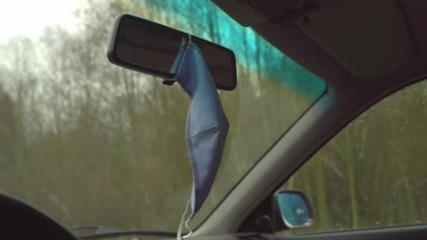 Η μάσκα στο αμάξι κρέμεται στον καθρέφτη του αυτοκινήτου.. — Αρχείο Βίντεο