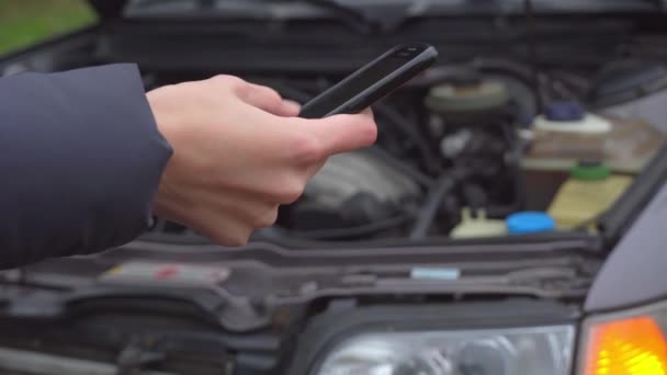 Közelkép a kéz segítségével telefon hátterében autó villogó riasztó — Stock videók