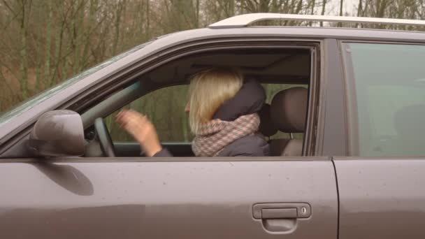 Ung blondin är arg och skriker medan du sitter bakom ratten. — Stockvideo