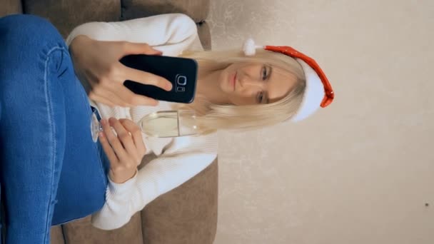 Die Blondine kommuniziert zu Weihnachten per Smartphone mit Verwandten oder Freunden. — Stockvideo