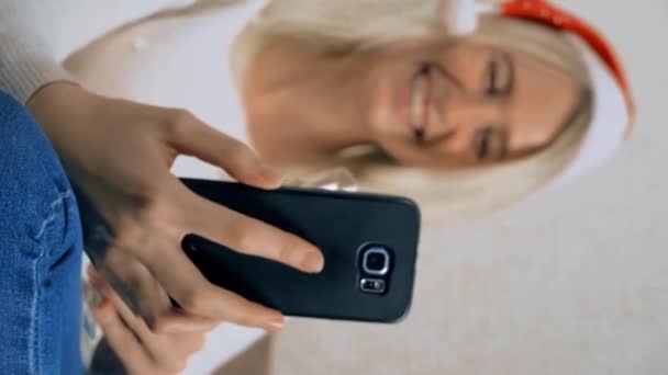 Блондинка спілкується через смартфон з рідними або друзями на Різдво . — стокове відео